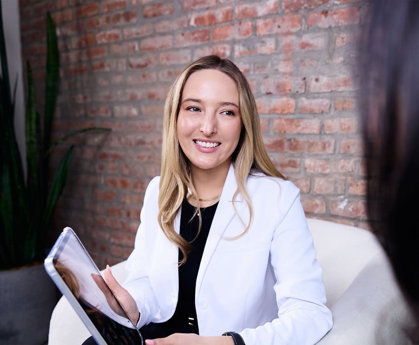Camille Mckee smiling at patient while holding ipad
