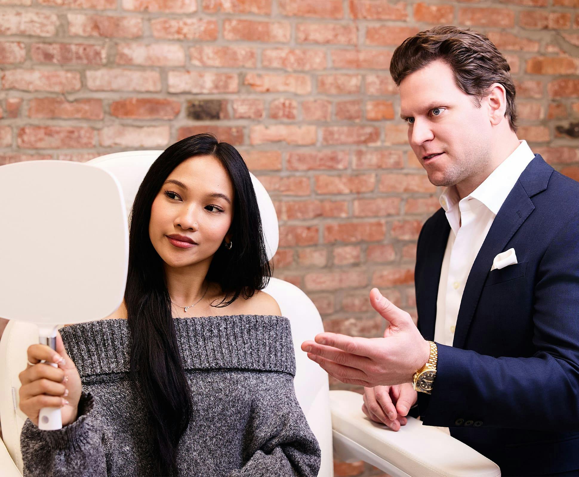Dr. David Porter with patient while she holds handheld mirror