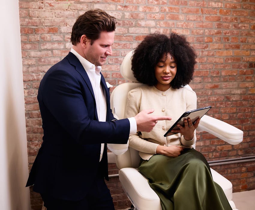 Dr. David Porter looking at ipad with patient sitting in exam chair