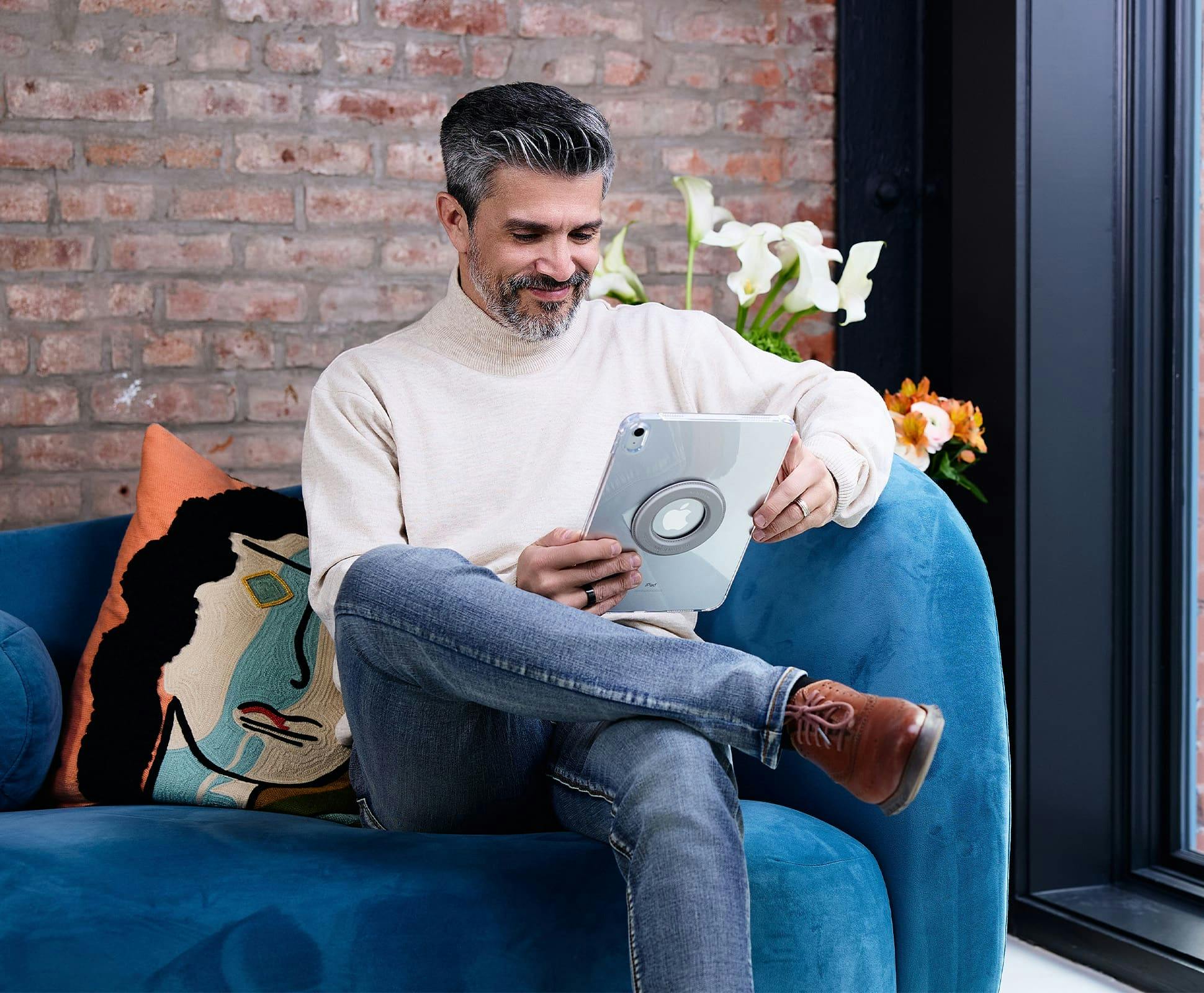 man sitting on couch with ipad in hand
