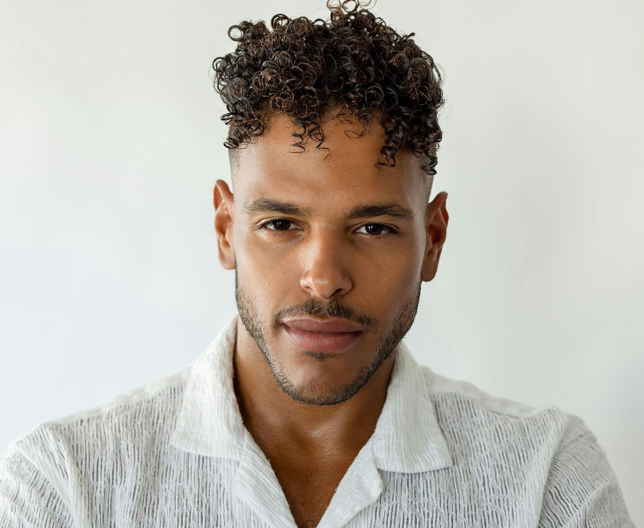man with curly hair looking forward