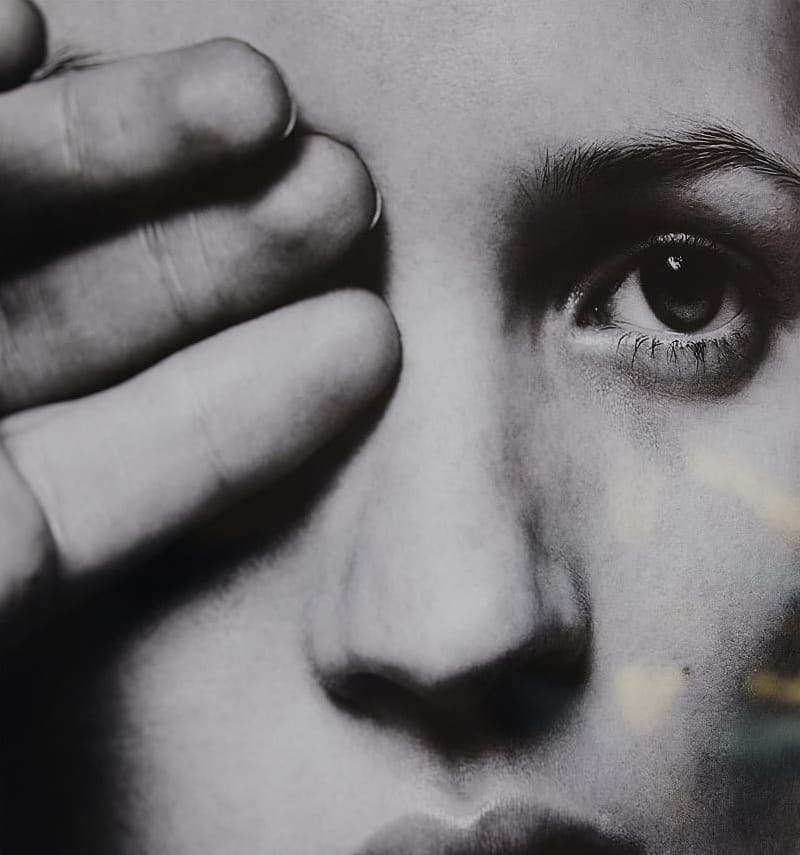 black and white image of person covering their eye