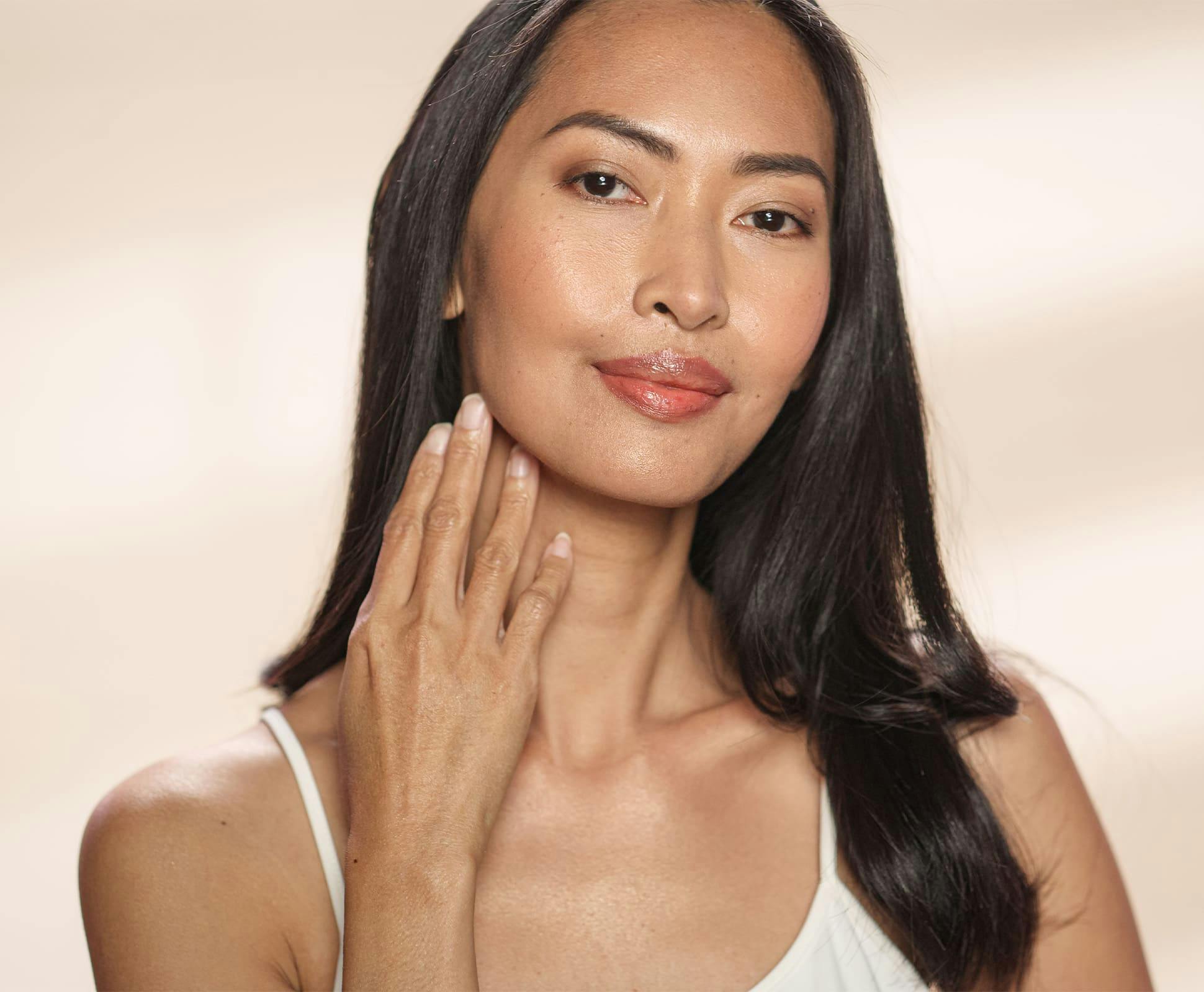 woman smiling and touching her jawline