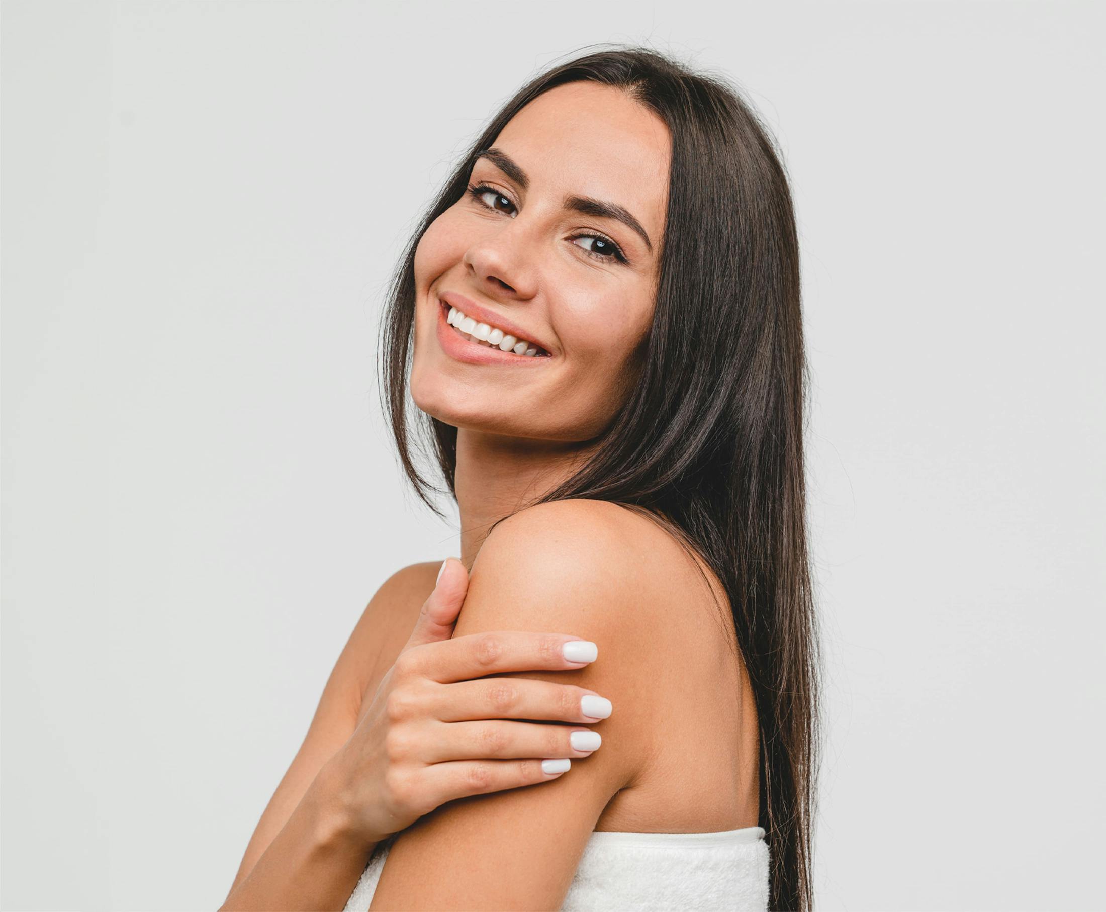 woman smiling facing the left with hand on her bicep