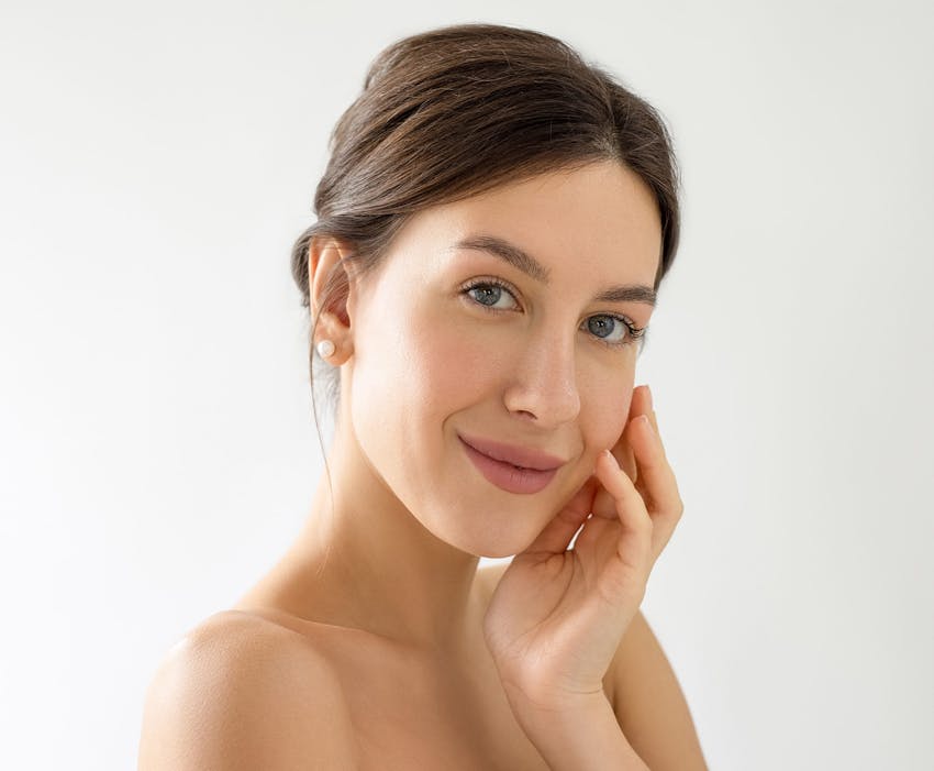 woman smirking and touching the side of her face