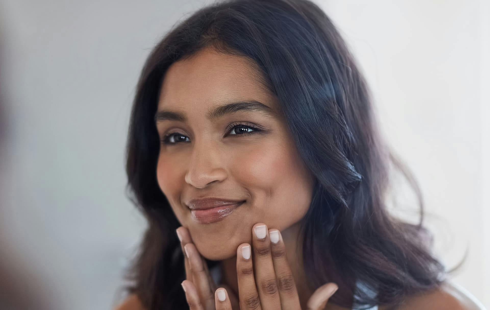 Woman smiling and touching face