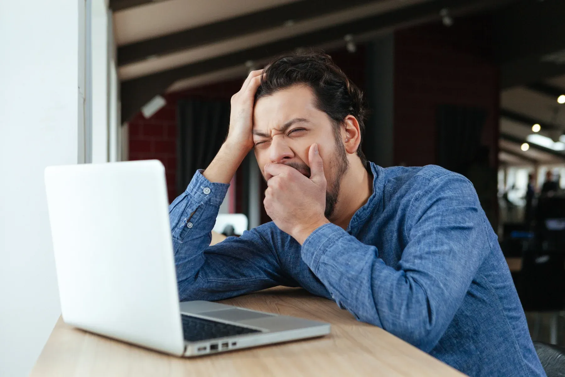 man yawning at desk