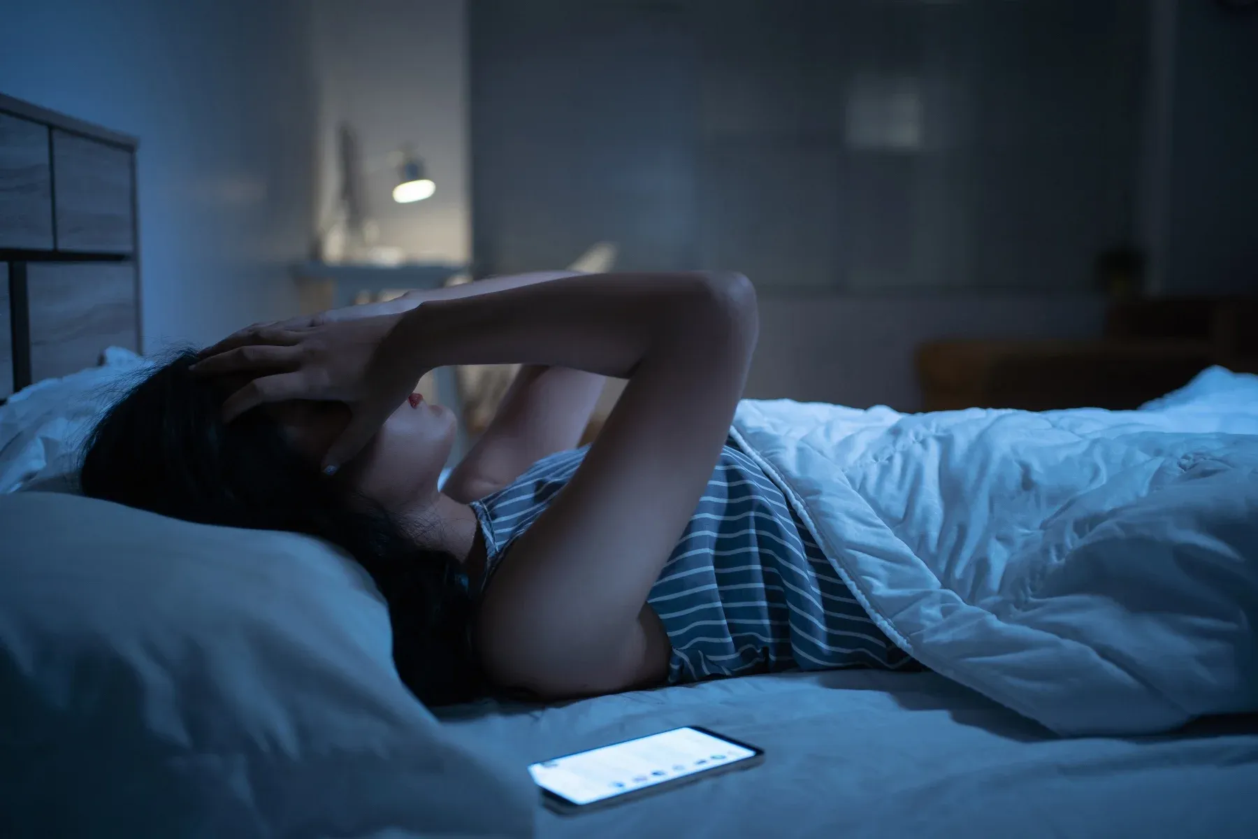 Women in bed scrolling on phone