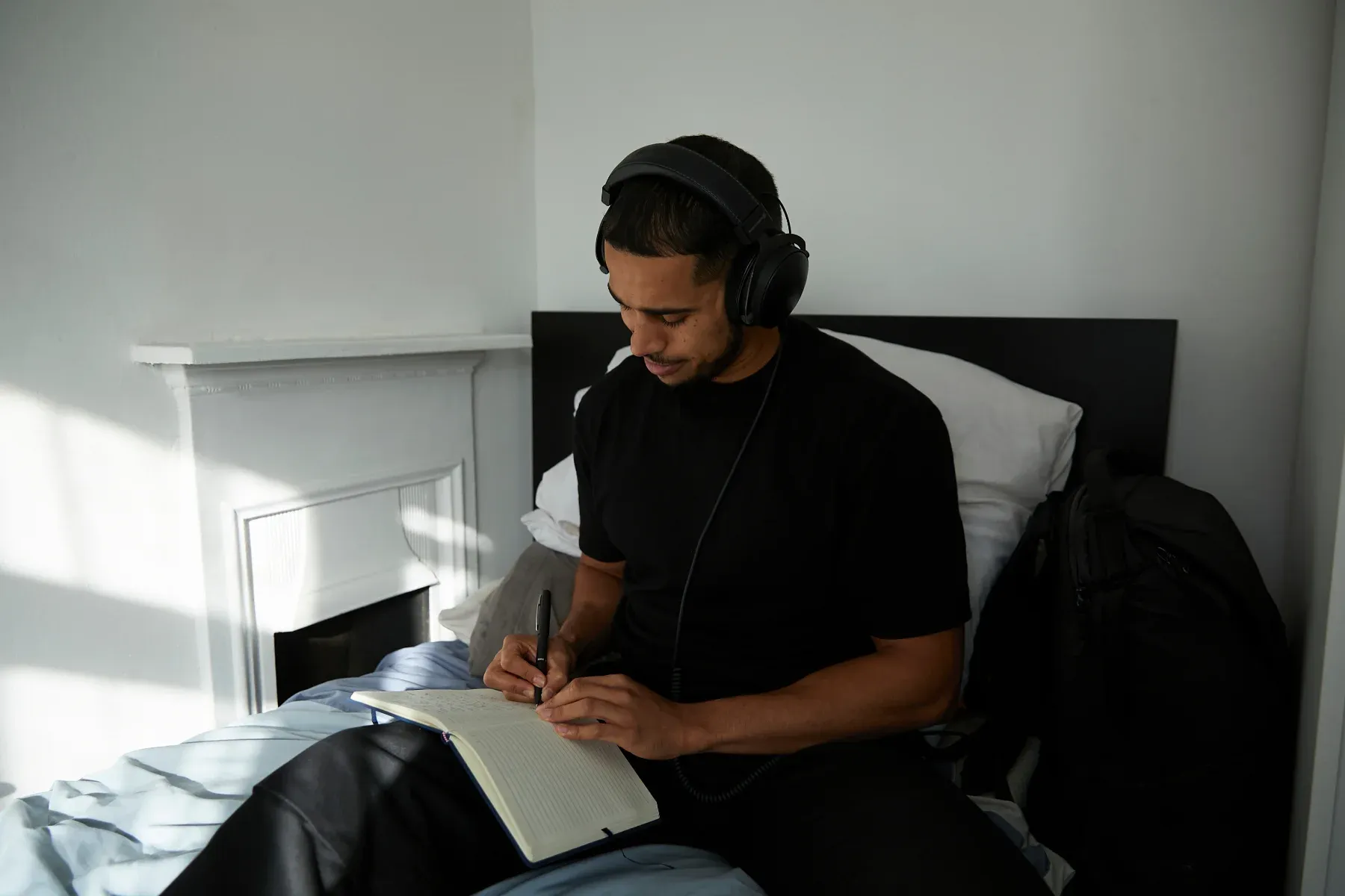 Man journaling in bed to reduce stress