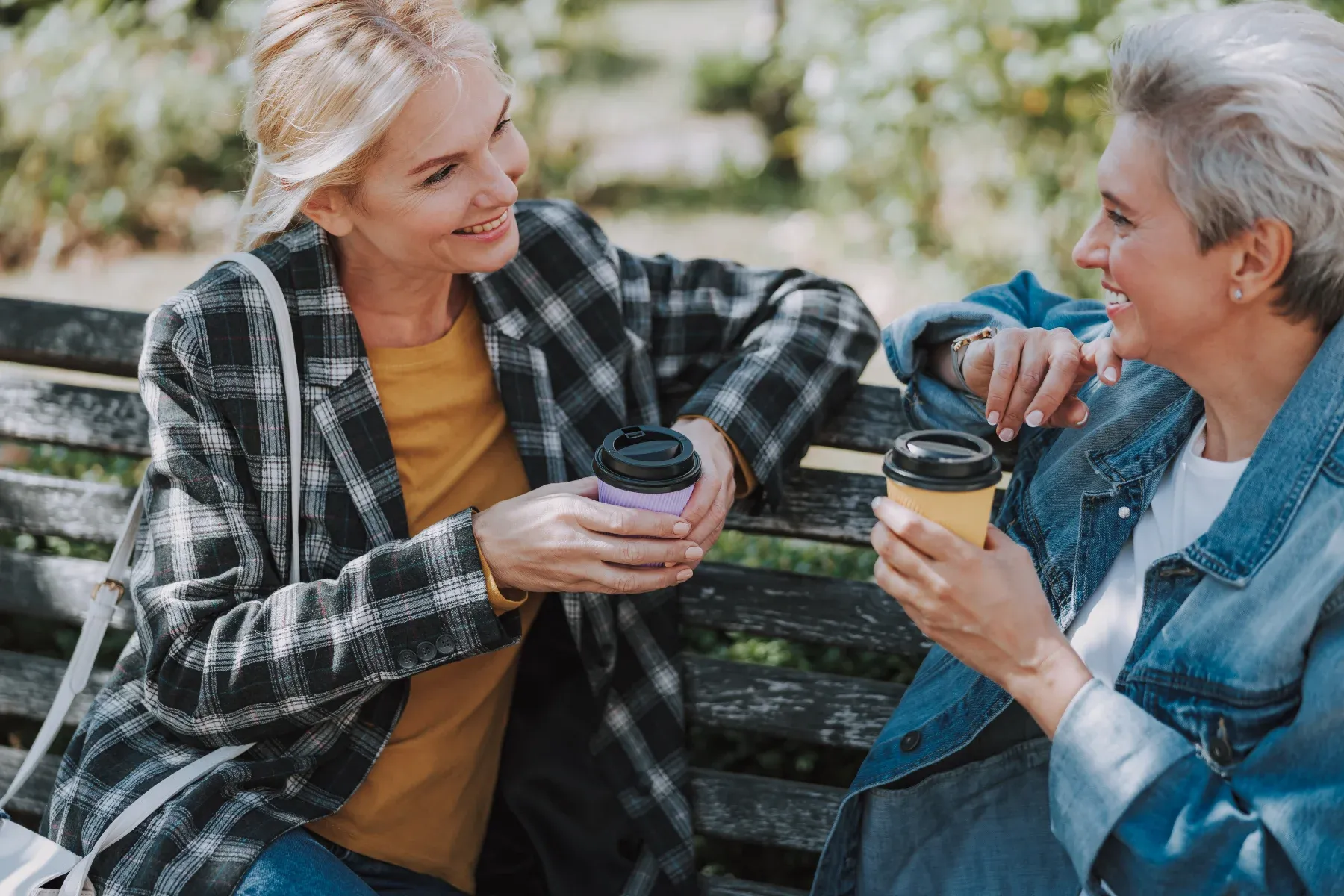 Women drinking coffee on a bench