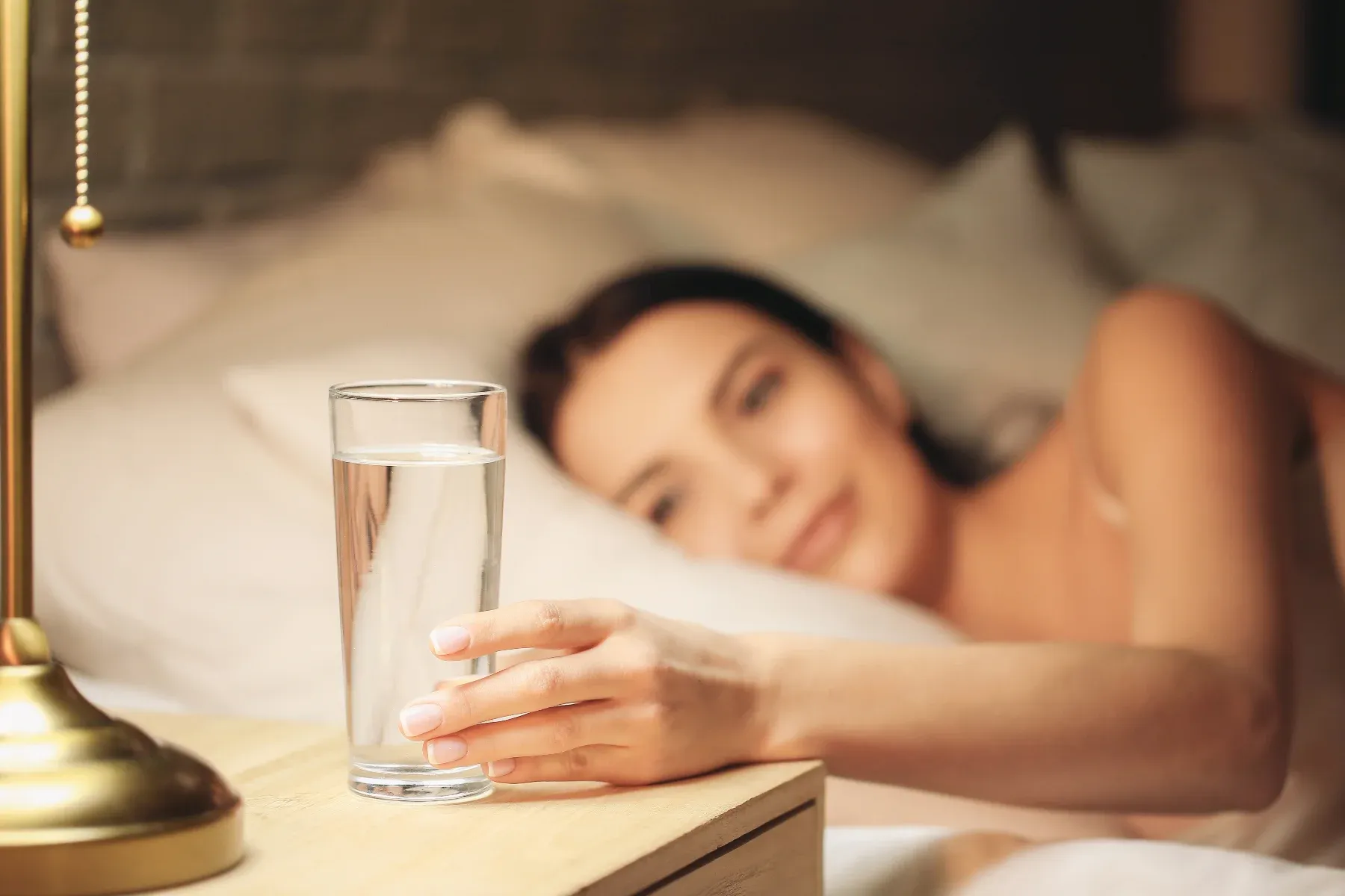 Female drinking water in bed