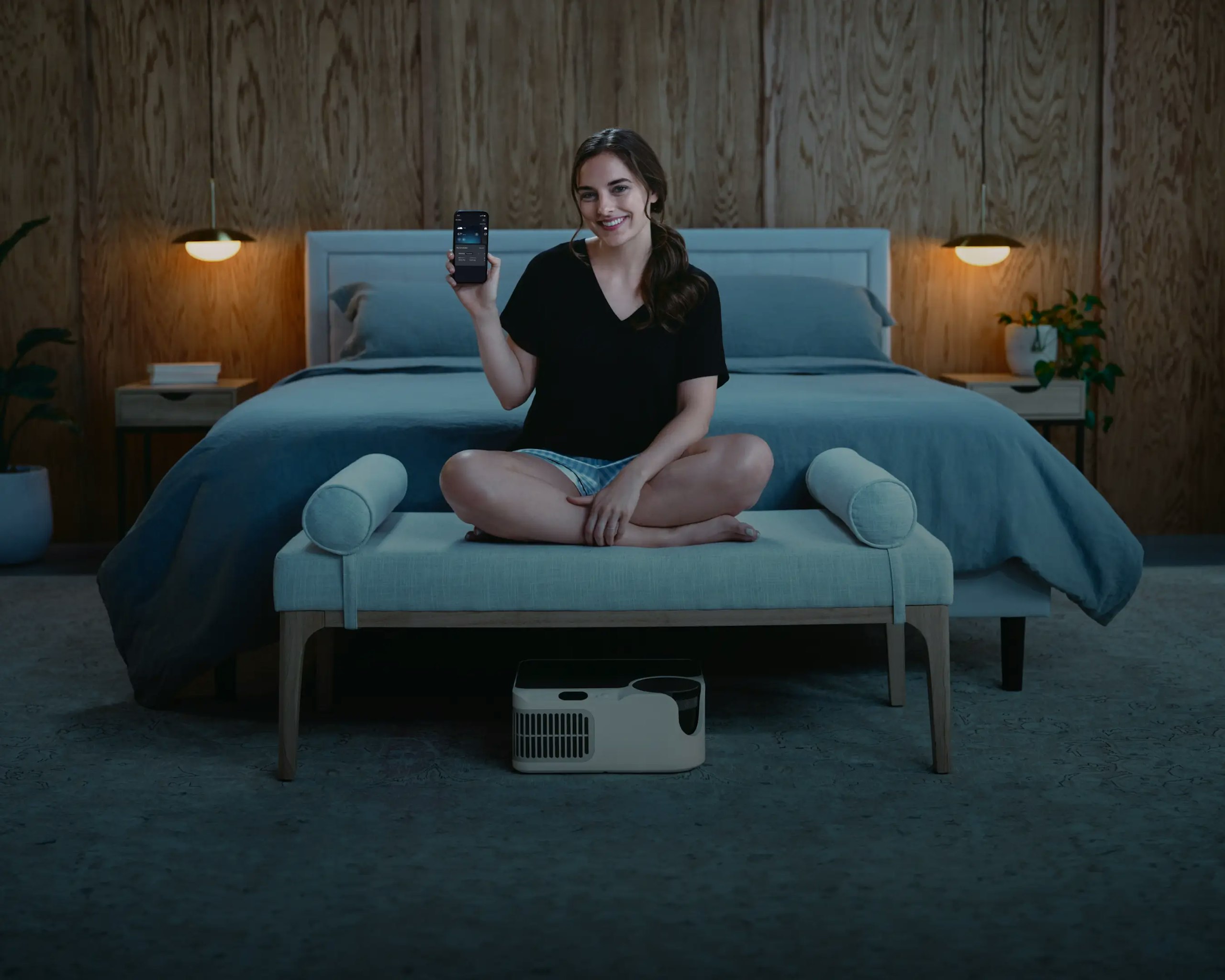 Woman using Chilipad app to control bed temperature with cooling sleep system under bed
