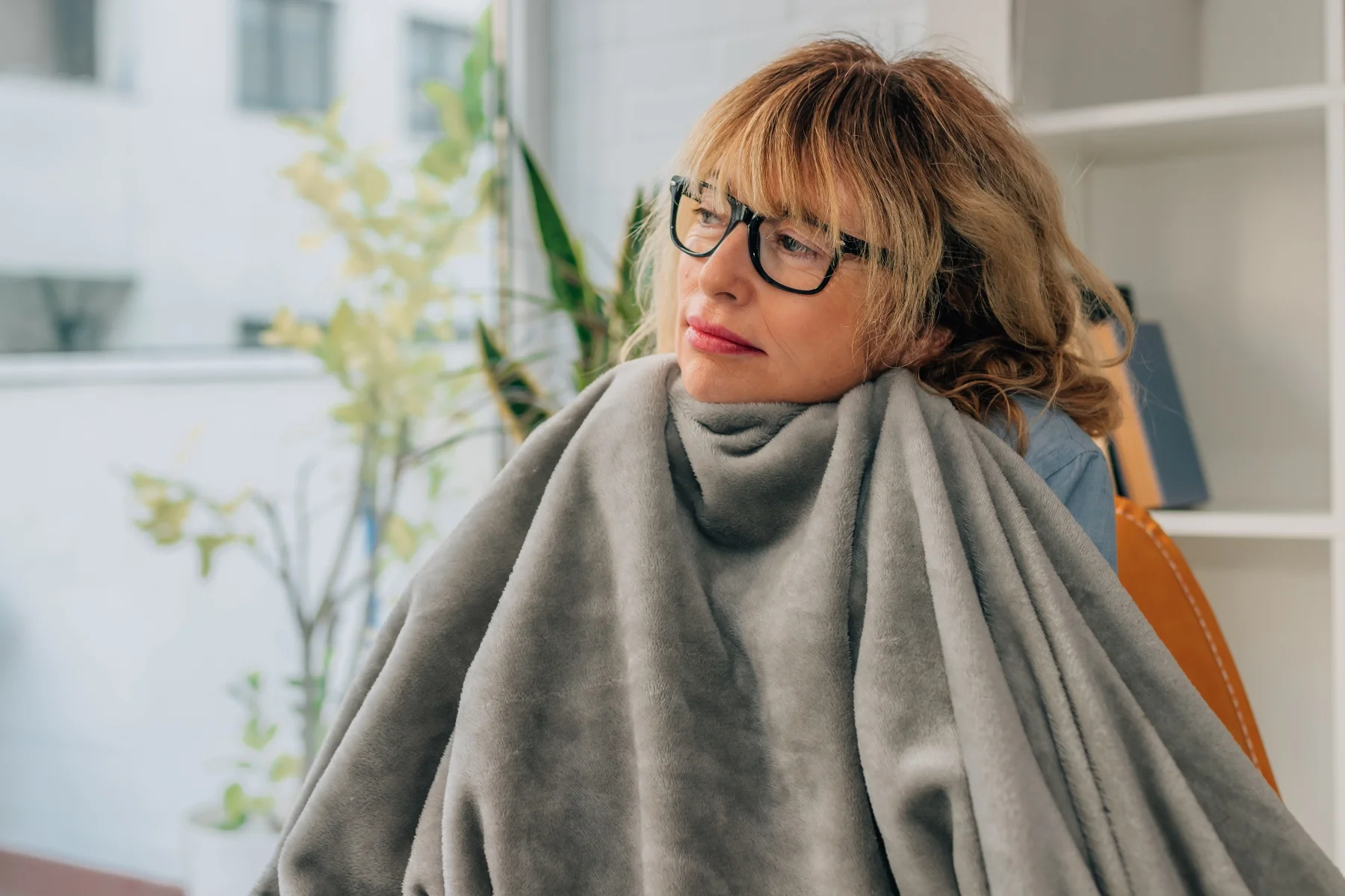 Women feeling cold using a blanket to stay warm