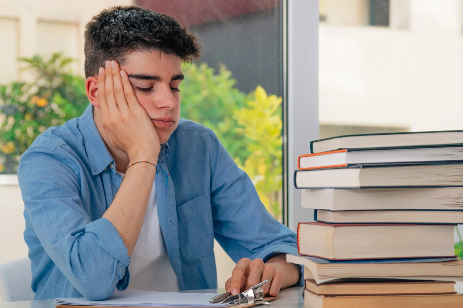 Teenage tired at home with school books