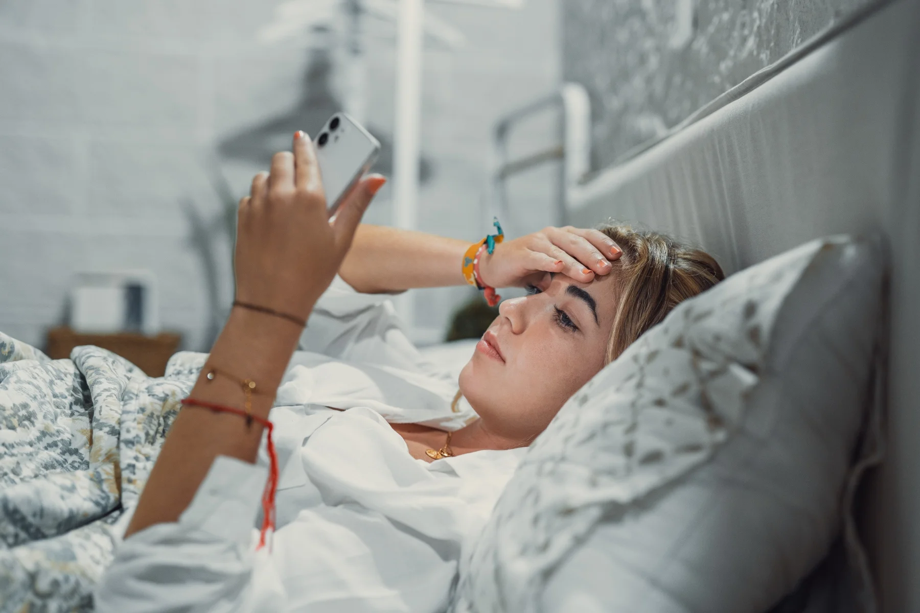 teenager in bed scrolling on their phone