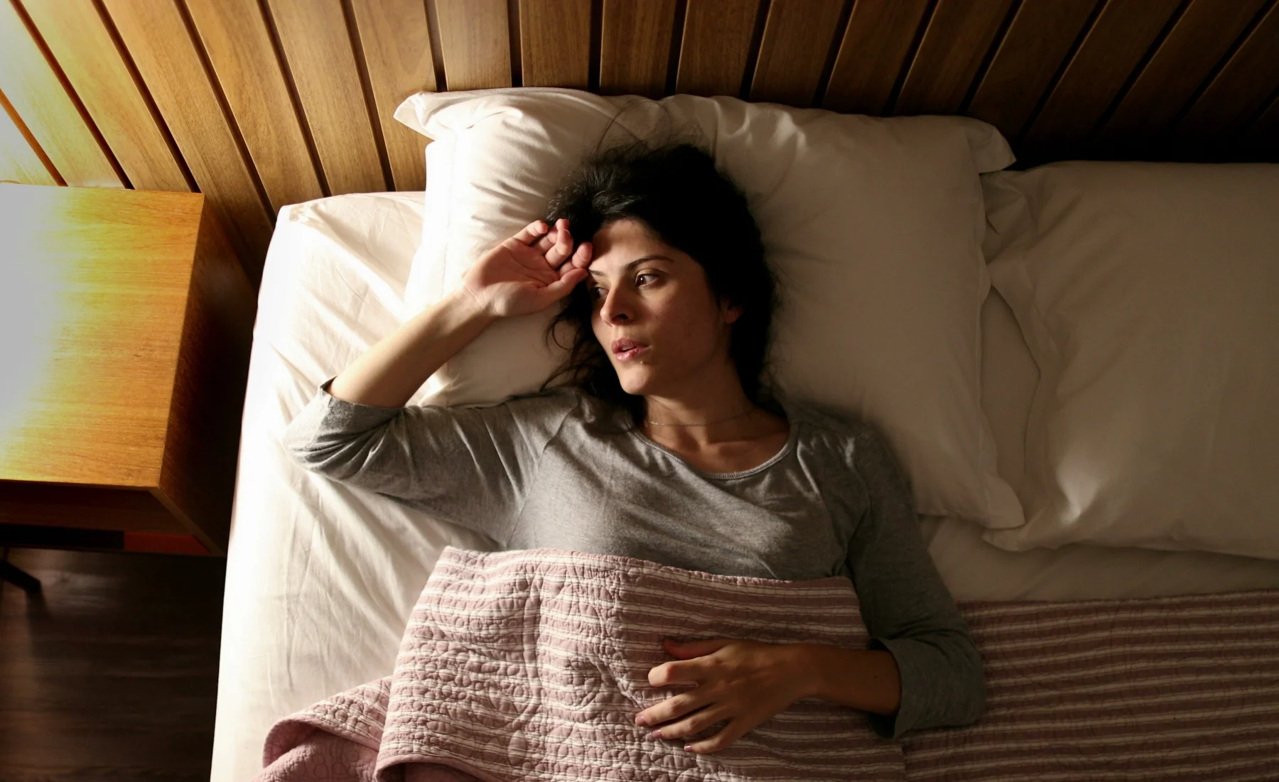 women in bed with anxiety