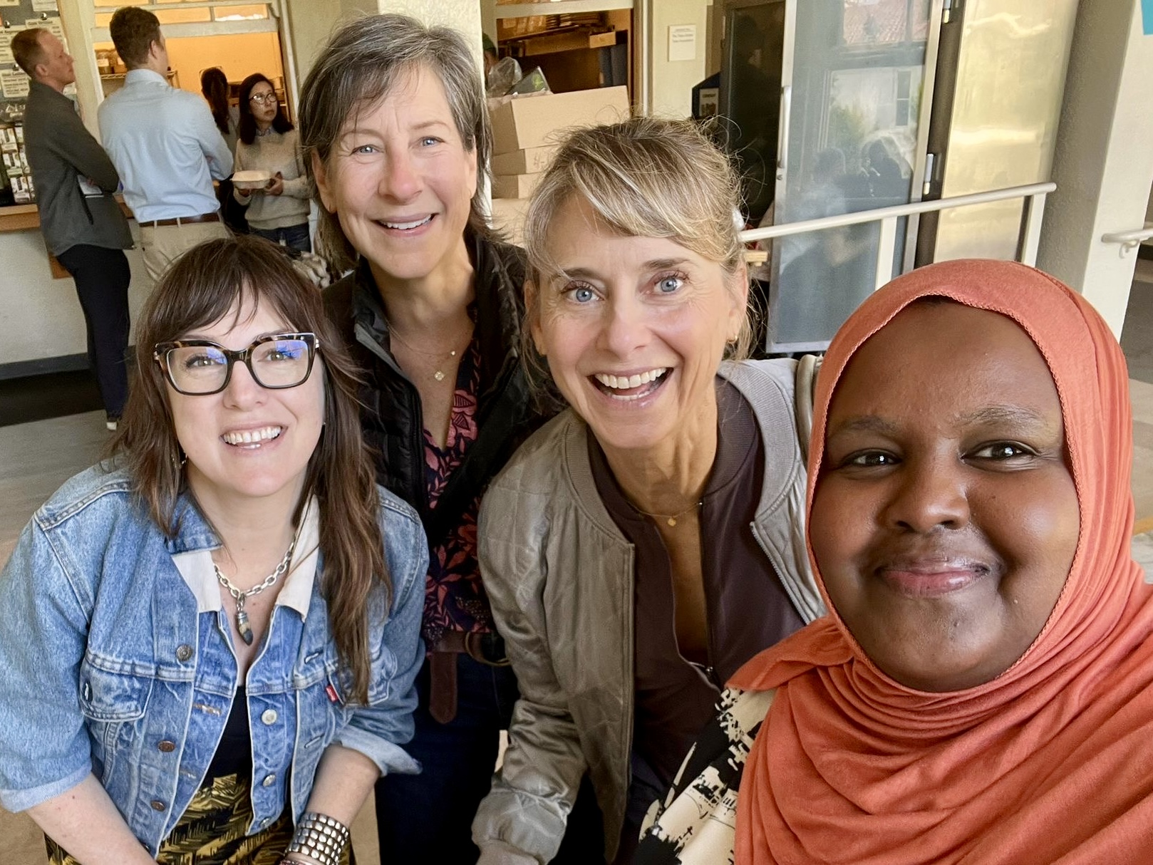 Four women smiling while looking into the camera