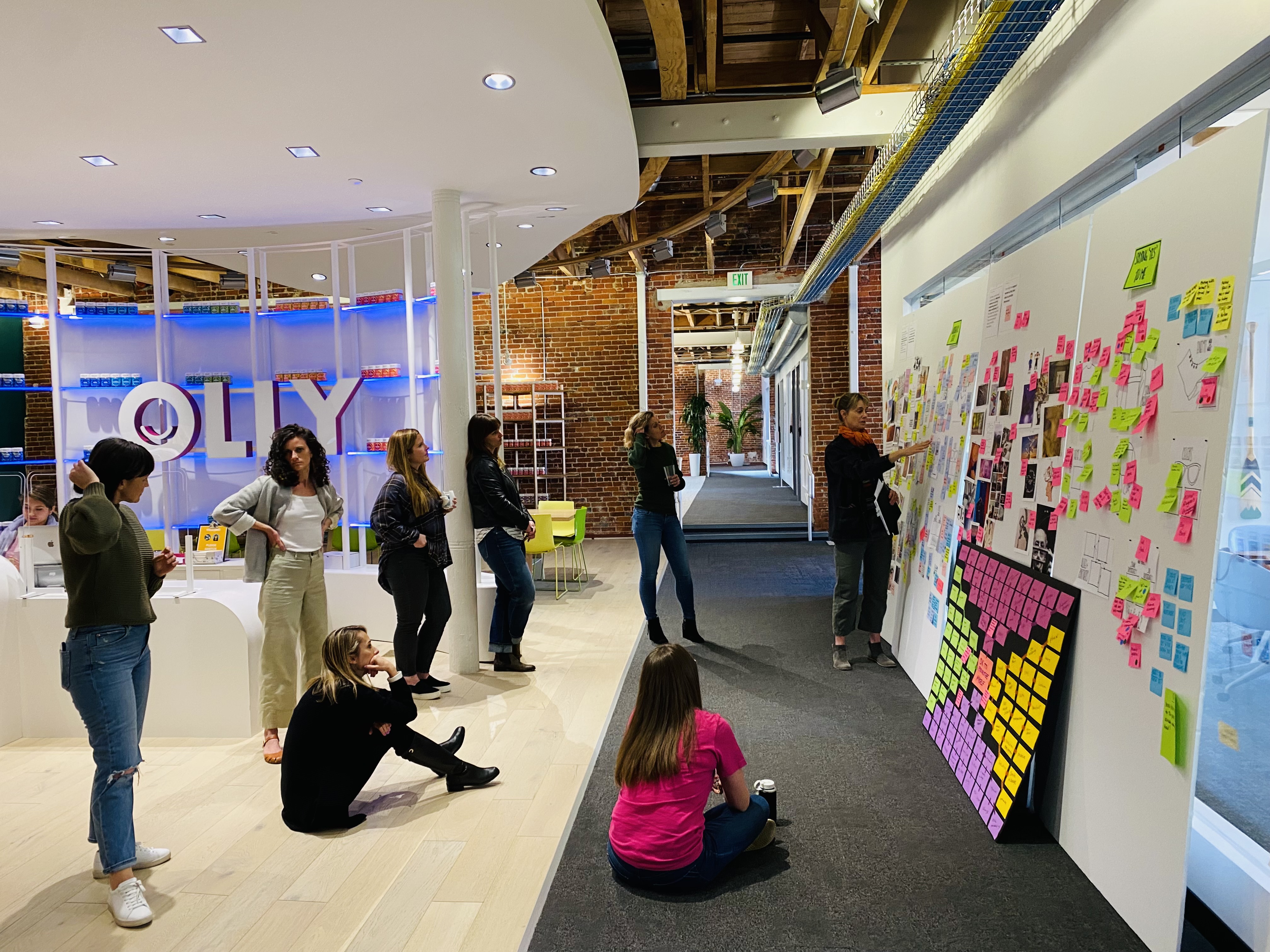 A group of people looking at boards with sticky notes on them.