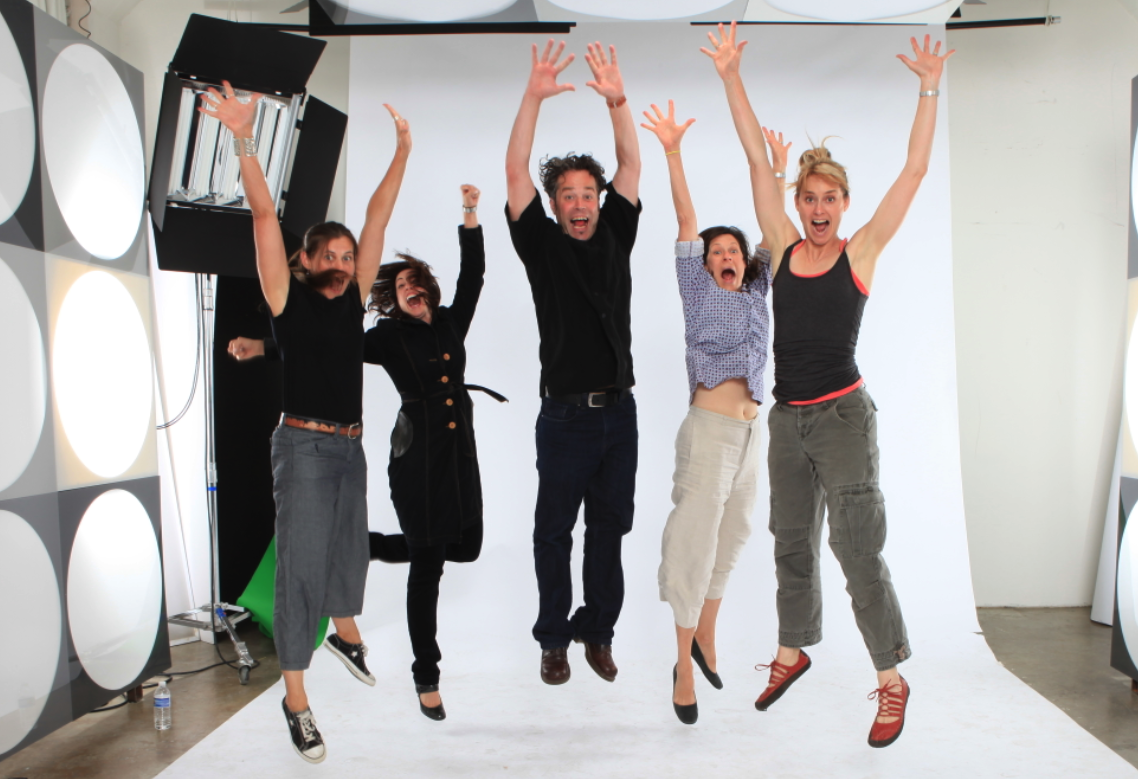 Five people jumping with their hands in the air