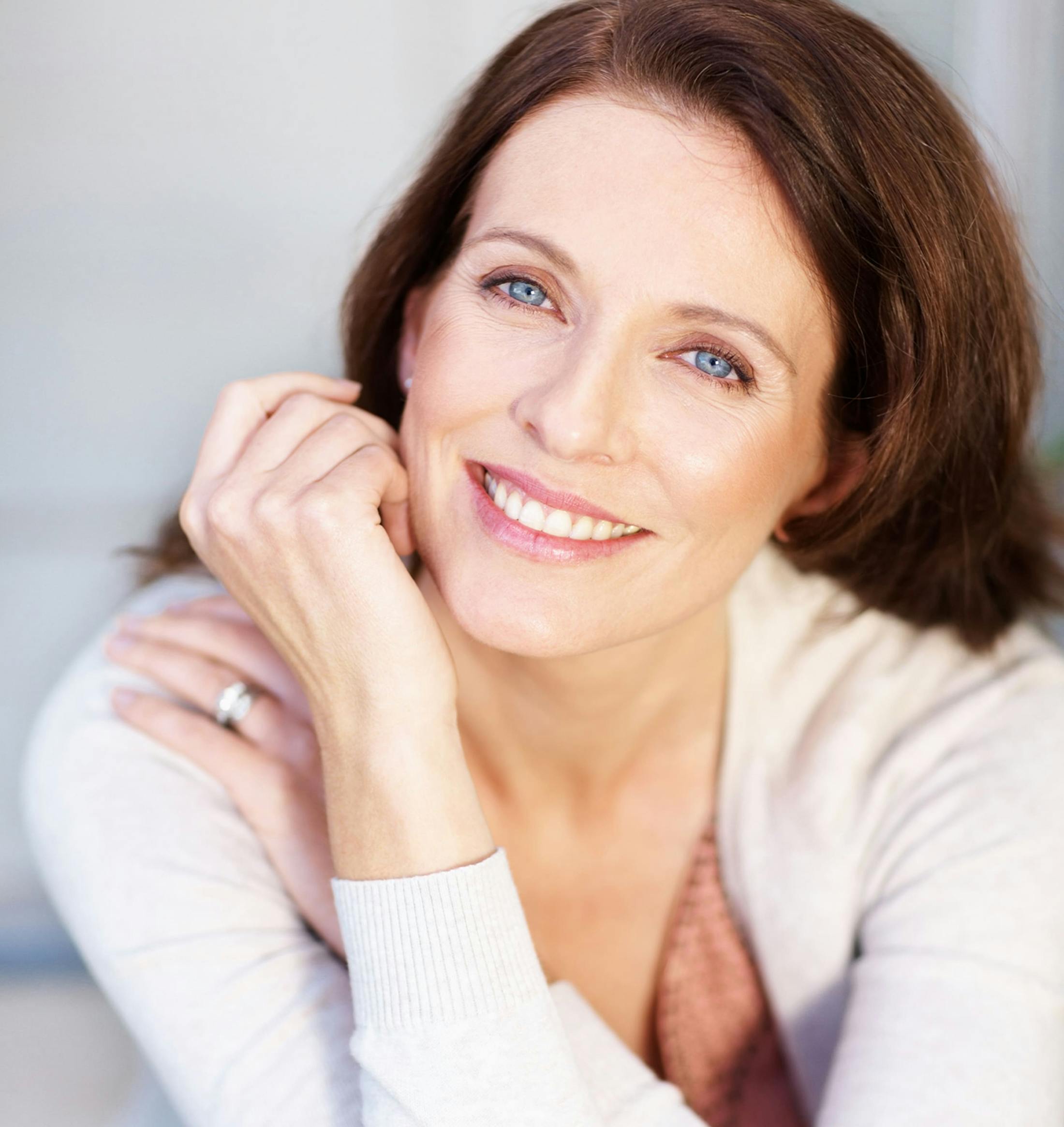 woman smiling with her hand near her face