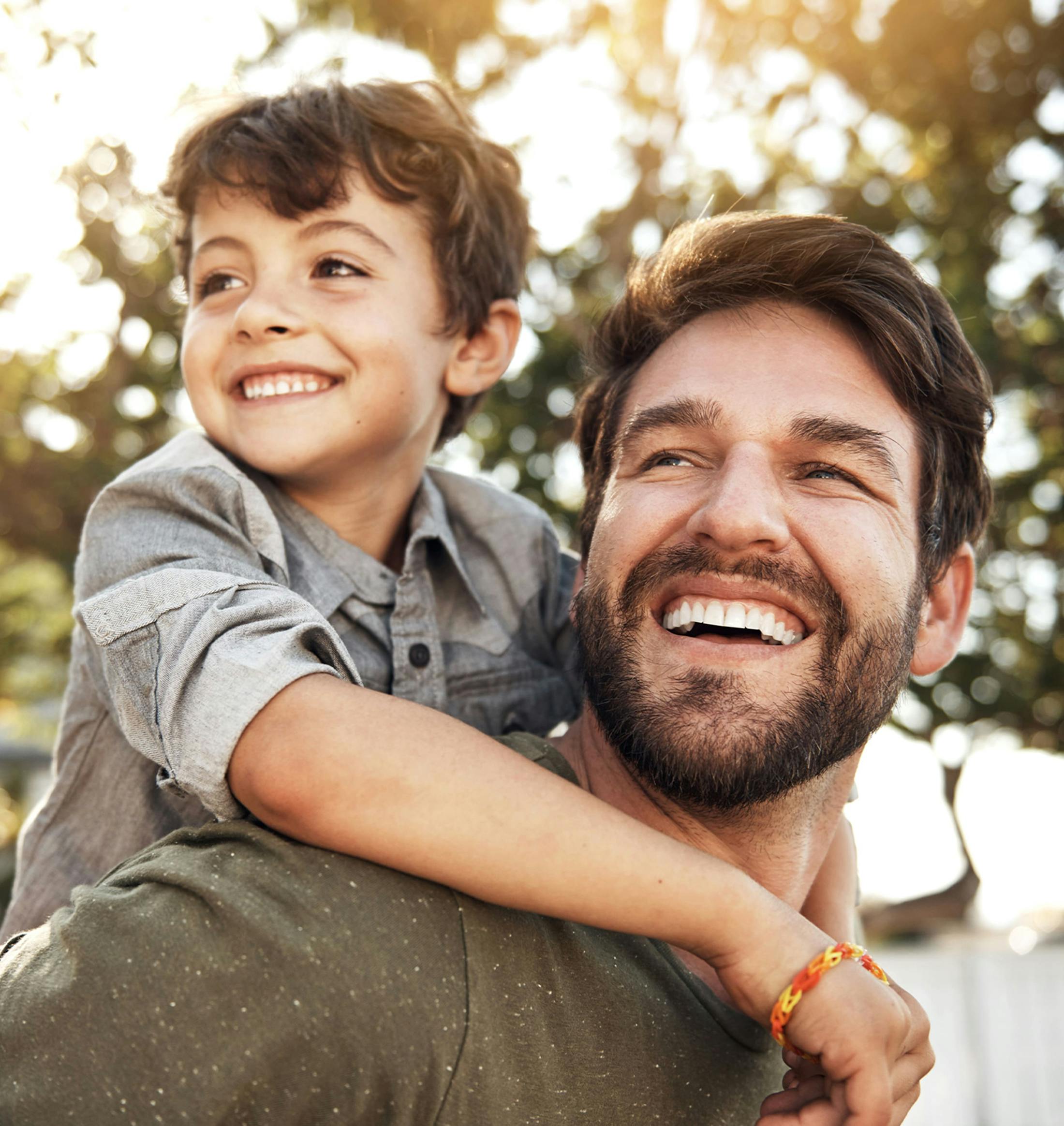 father giving his son a piggy-back ride