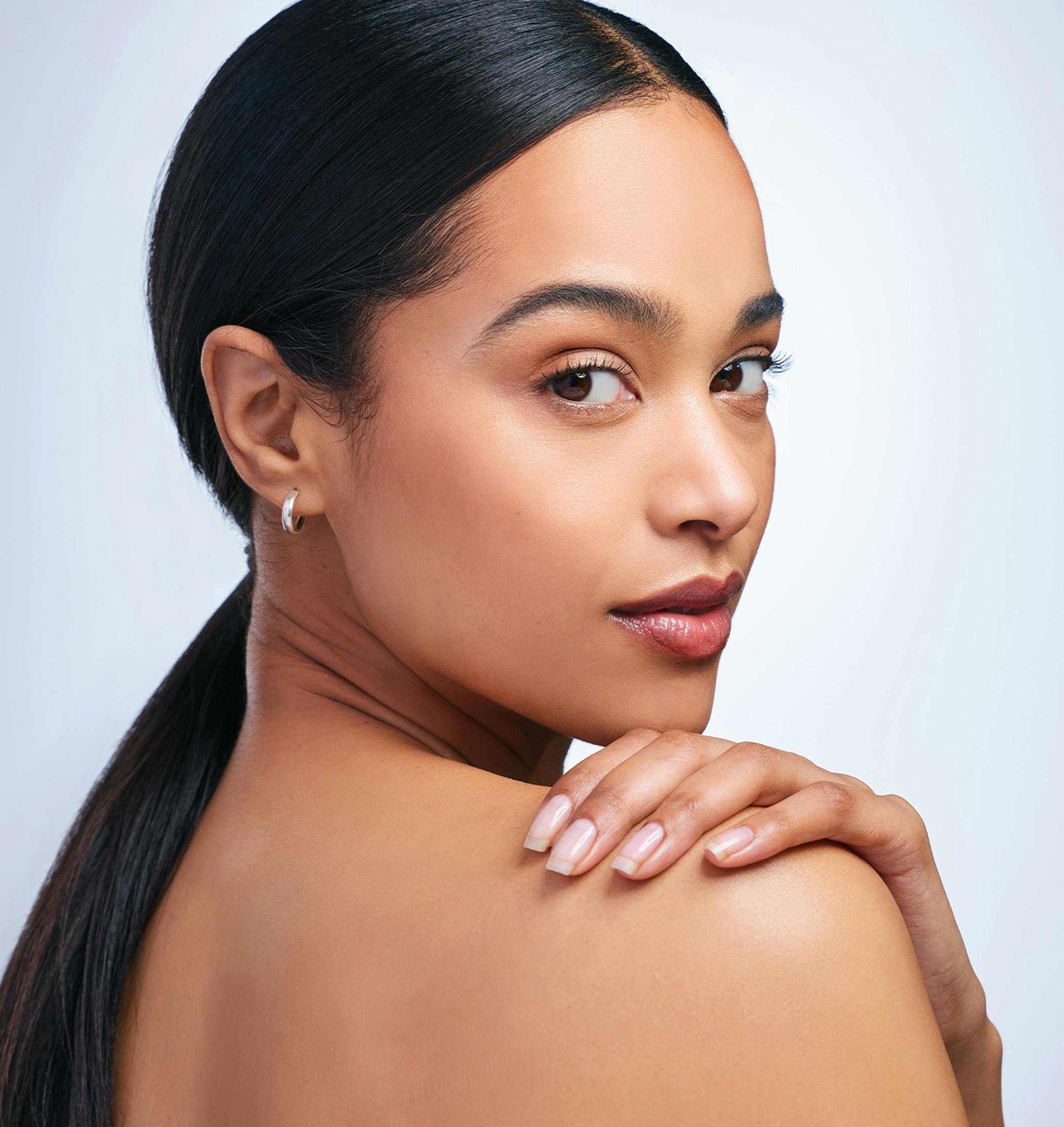 woman with ponytail and hand on shoulder