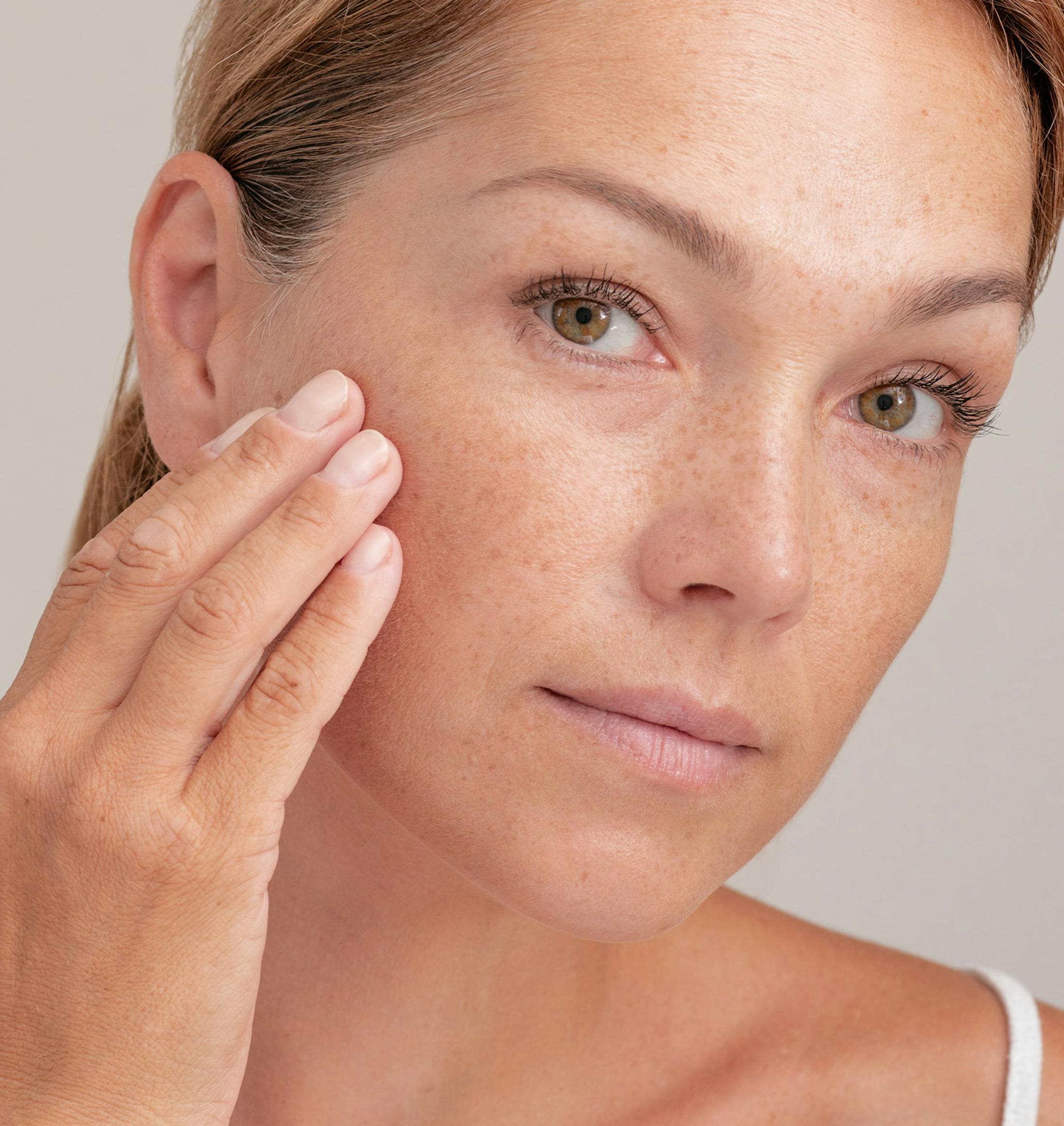 woman touching her cheek