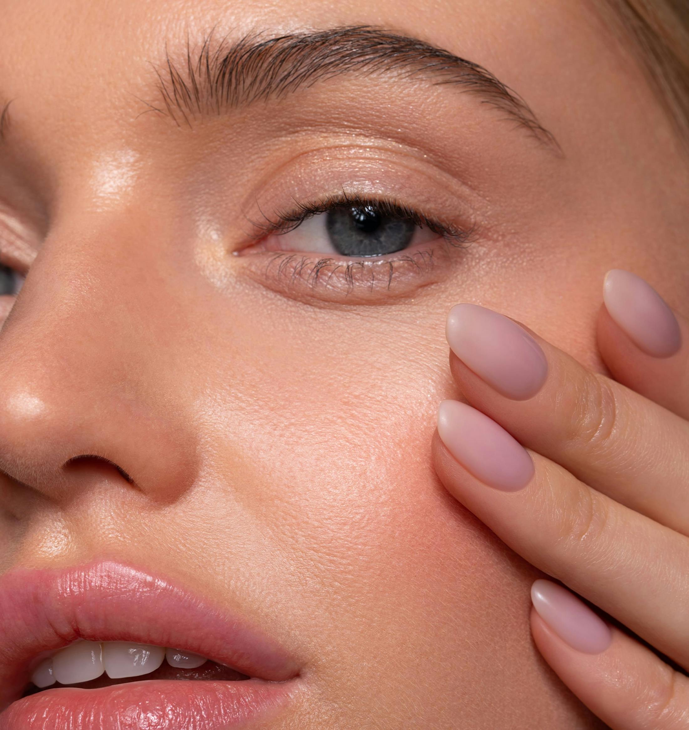 close up on woman's face with her hand on her cheek