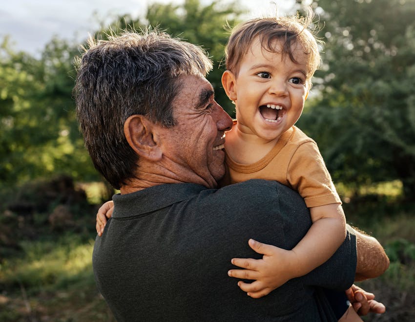 man holding toddler as toddler is smiling