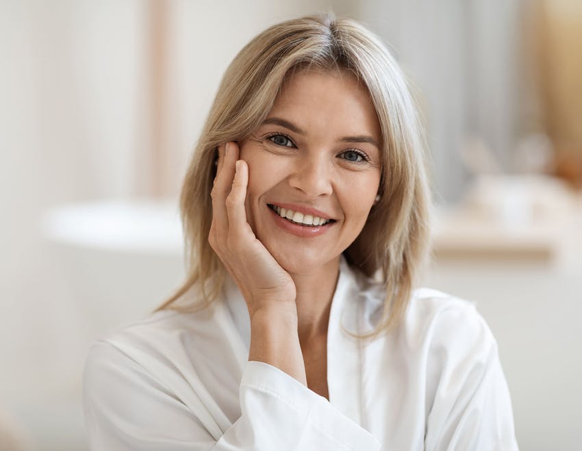 woman smiling with hand on her cheek