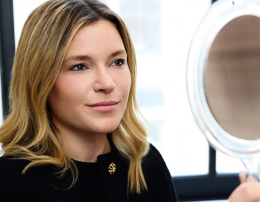 female patient looking into handheld mirror