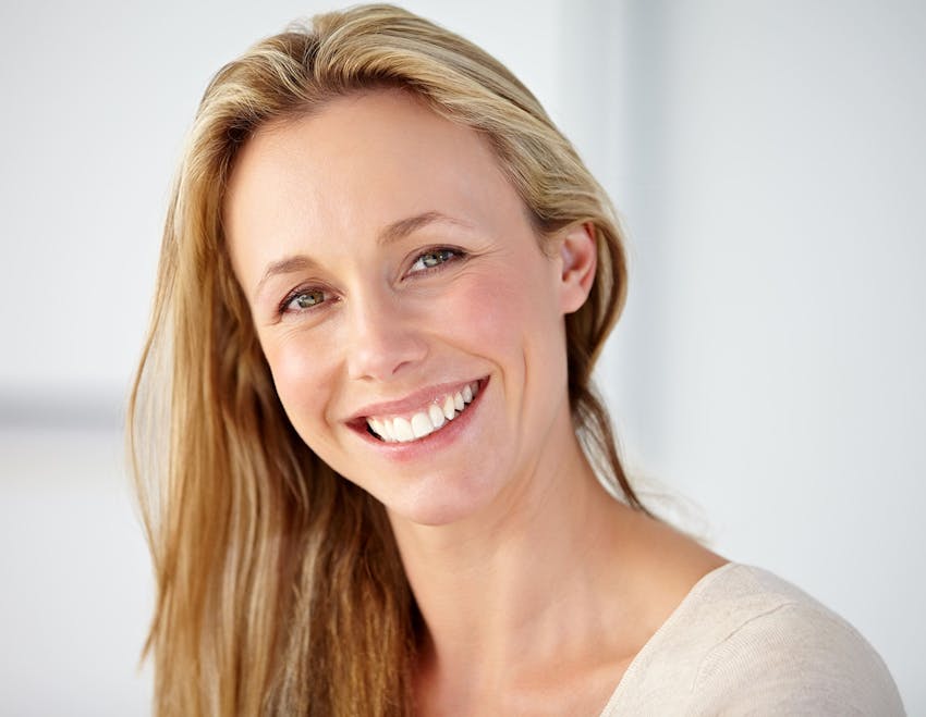 woman with hair thrown to one side smiling