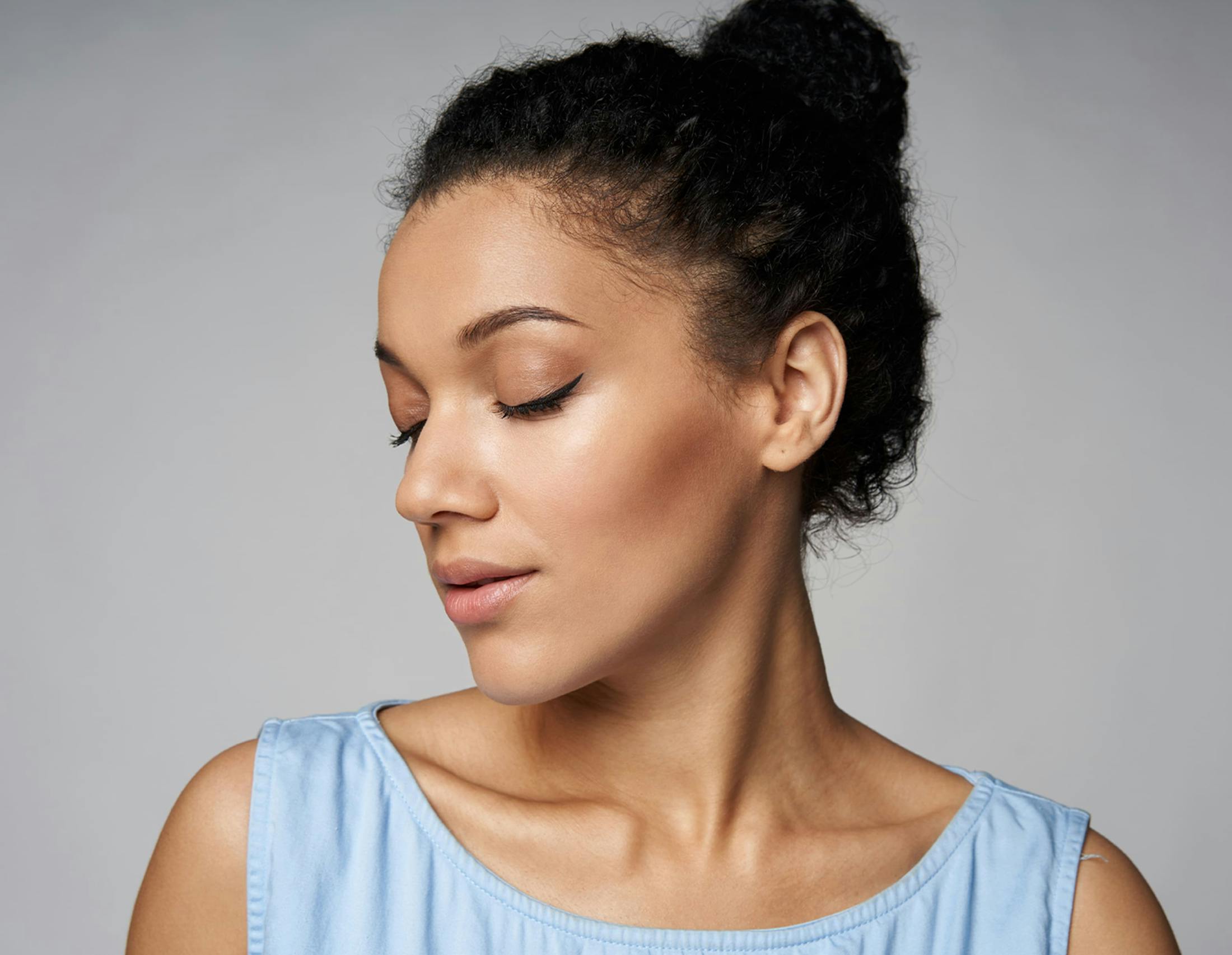 woman with her hair tied up and facing the left