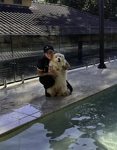 Staff member and happy dog by the pool during Doggy Daycare at Pet Resorts Australia Terrigal, a top dog resort offering water play, outdoor fun and expert care as part of its dog daycare program in Terrigal.