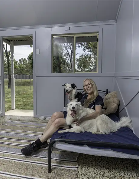 Dog relaxing with a carer inside the Social Room at Pet Resorts Australia Townsville – spacious and homely dog boarding option