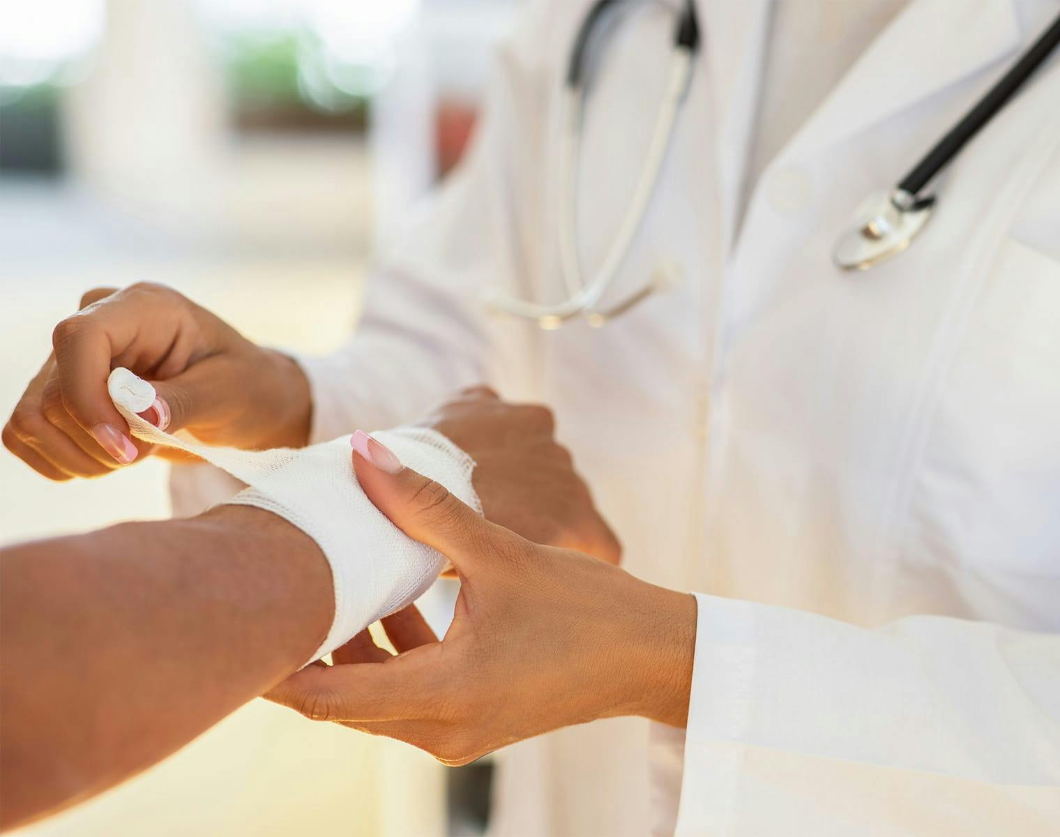 doctor wrapping a patient's wrist in gauze