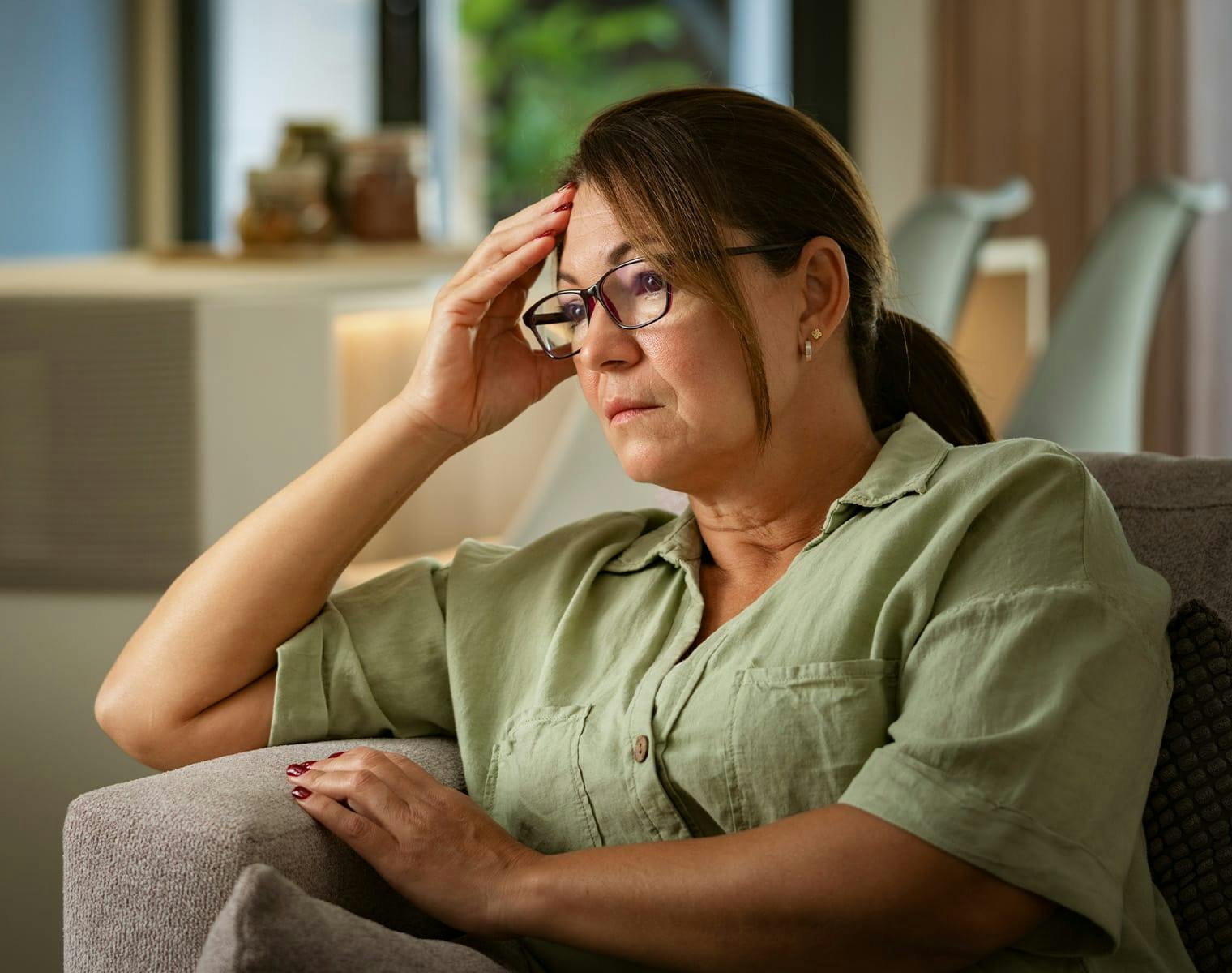 woman looking distressed, sitting on a couch