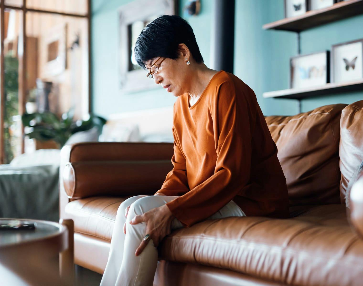 Woman holding her leg on a couch