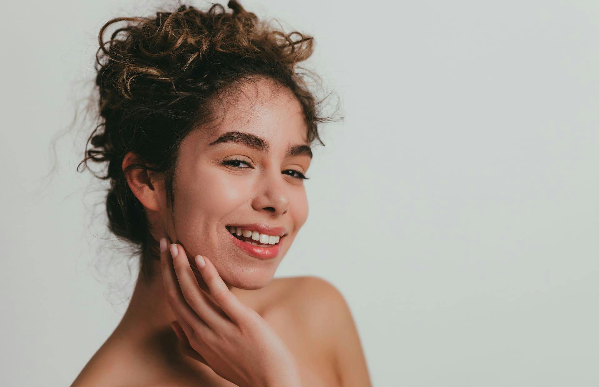 Woman smiling with hand on face