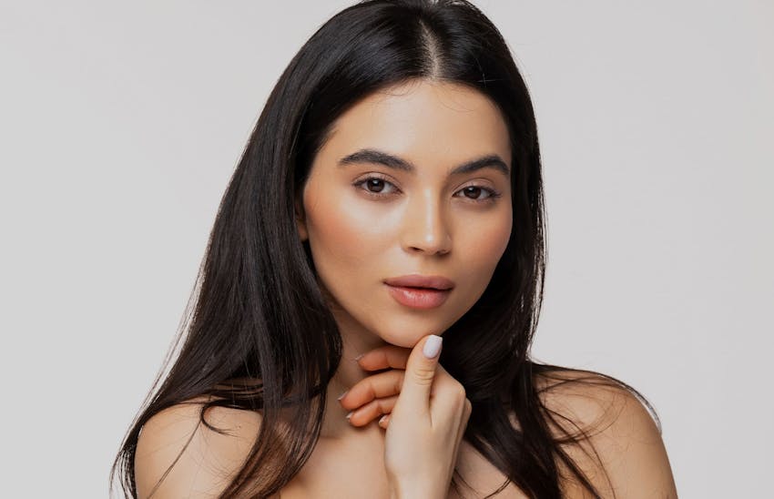 Woman touching chin with thumb