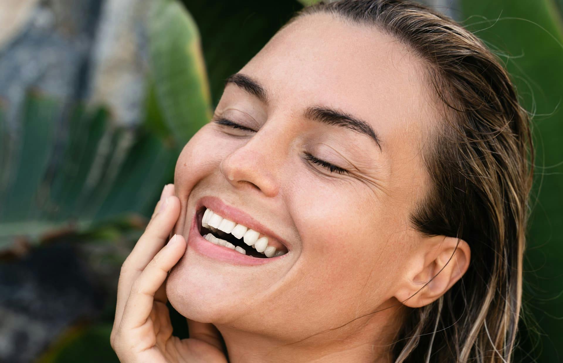 Woman laughing with hand on face