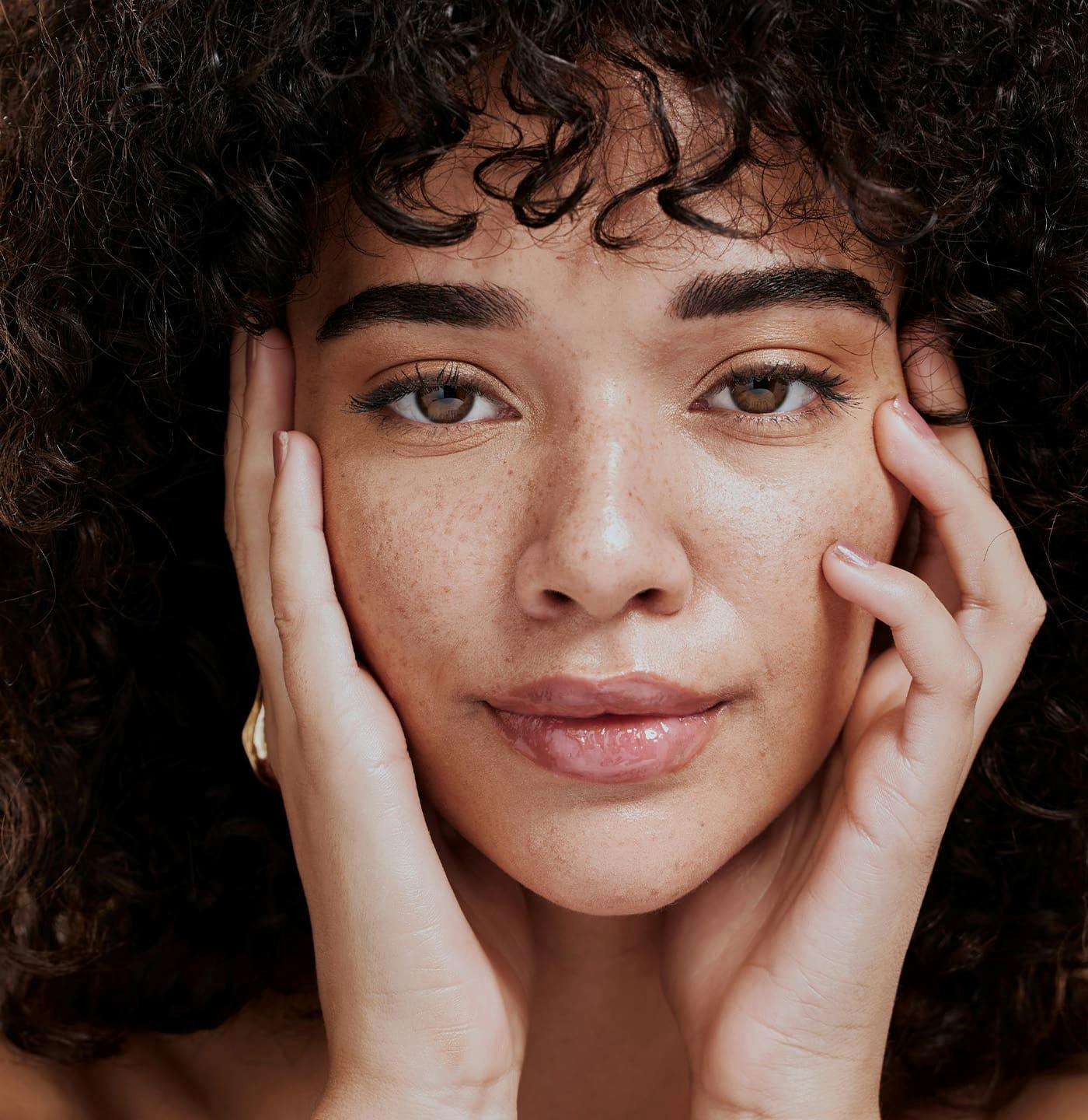 Woman smiling and touching face
