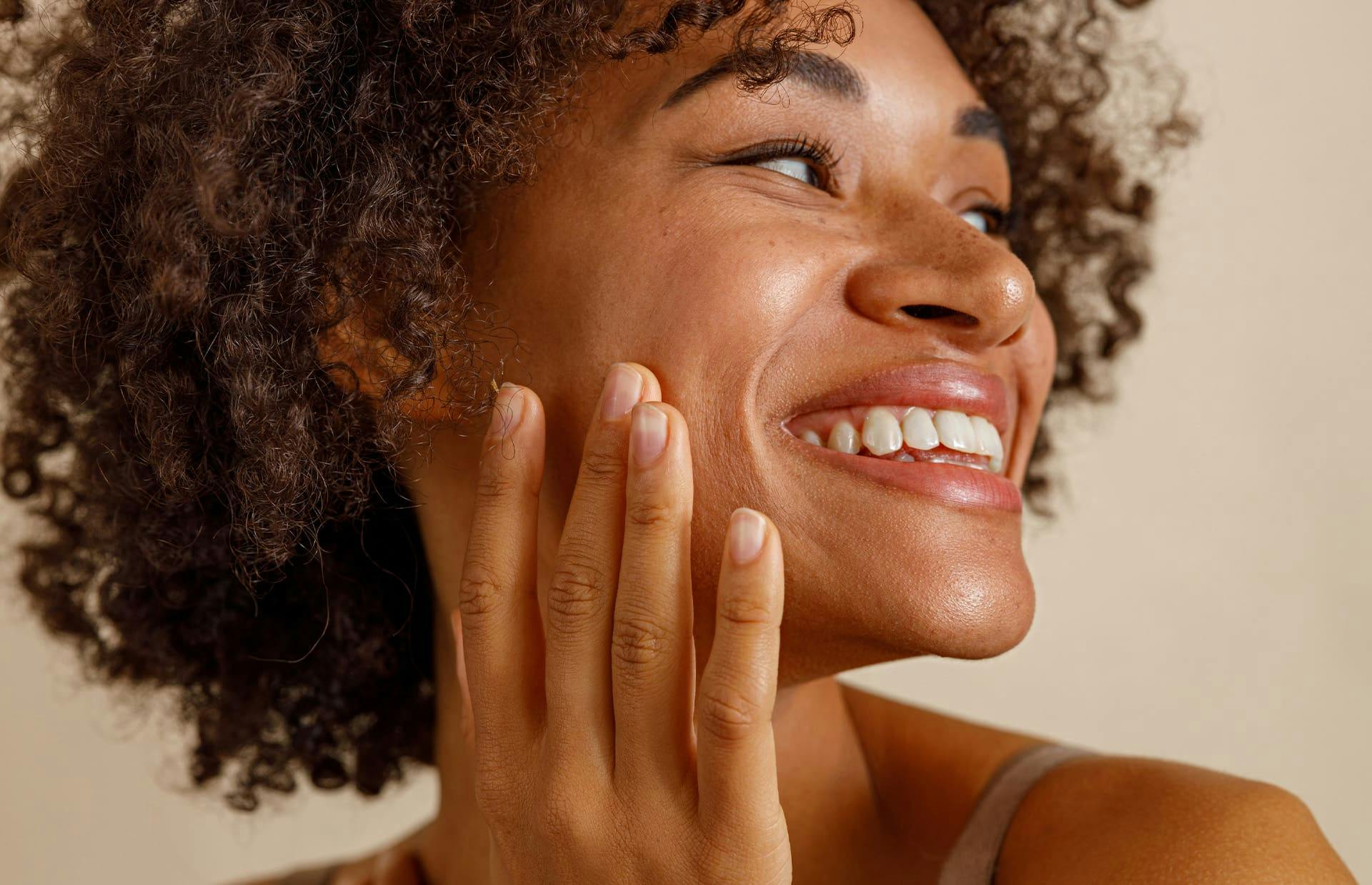 Woman smiling with hand on cheek