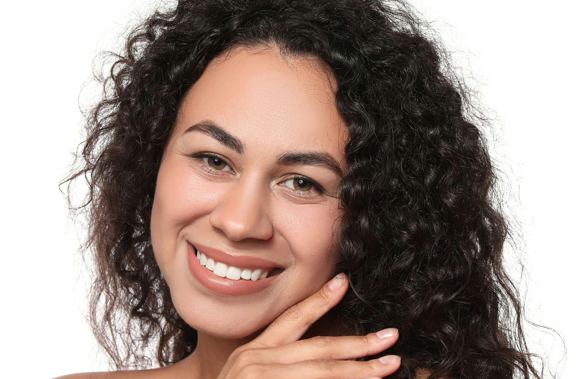 Woman smiling with hand touching face