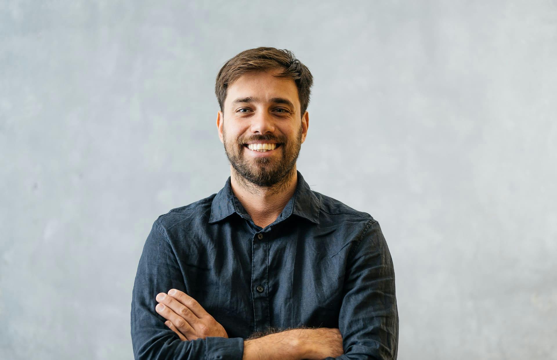 Man smiling while crossing arms