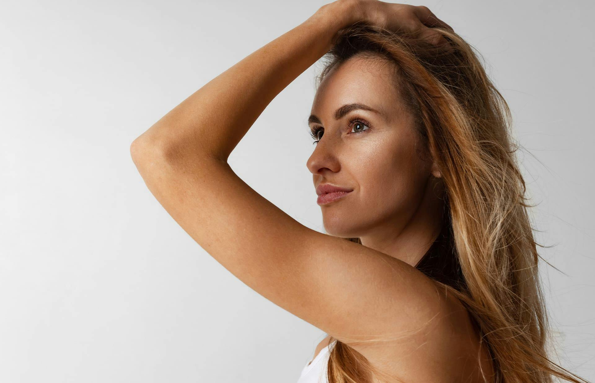 Woman running hand through hair and smiling