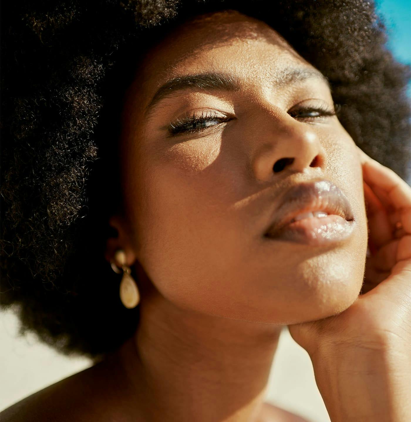 Woman looking down at camera resting chin on hand