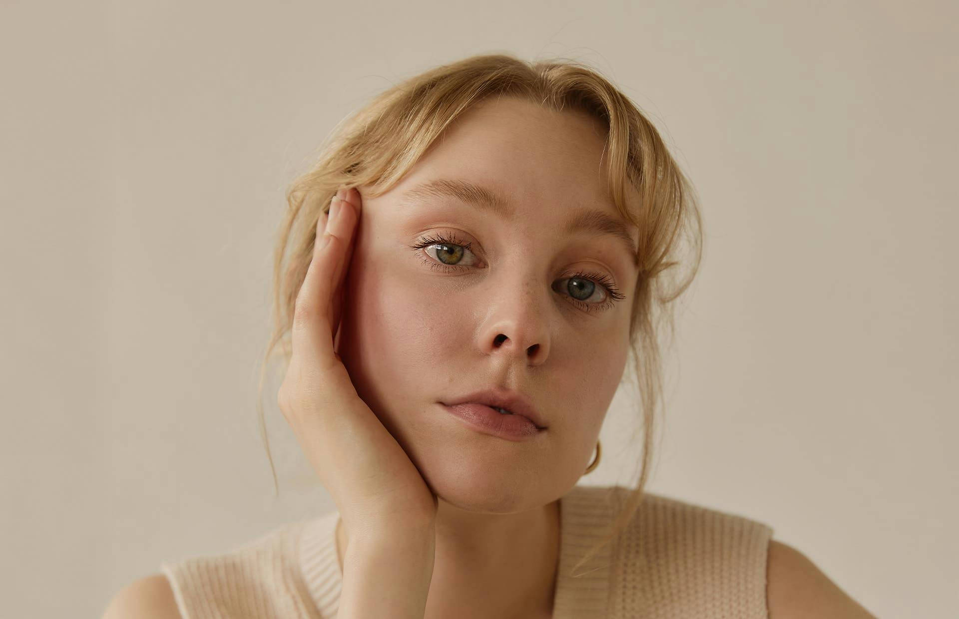 Woman with hand on side of head