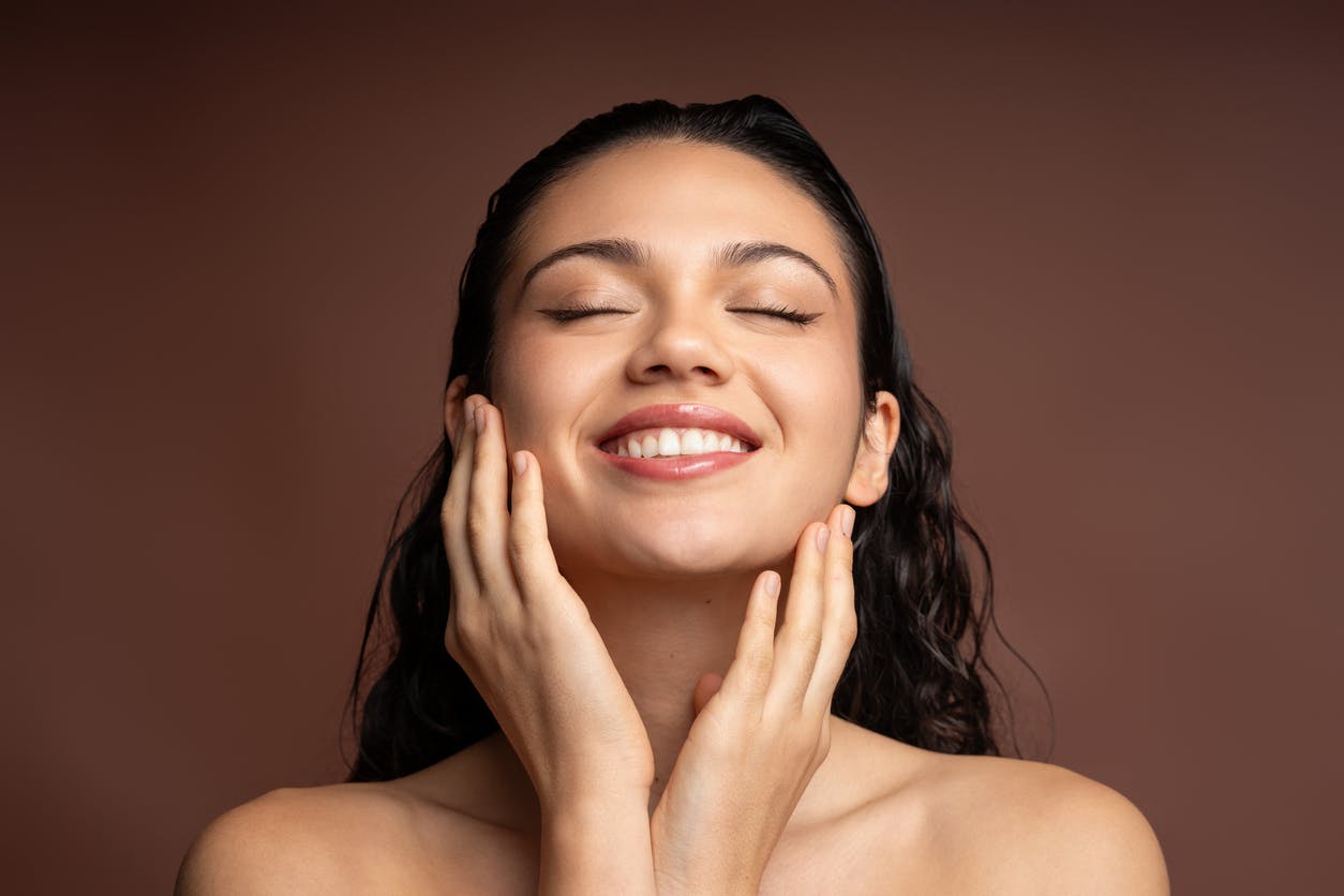woman holding her face and smiling