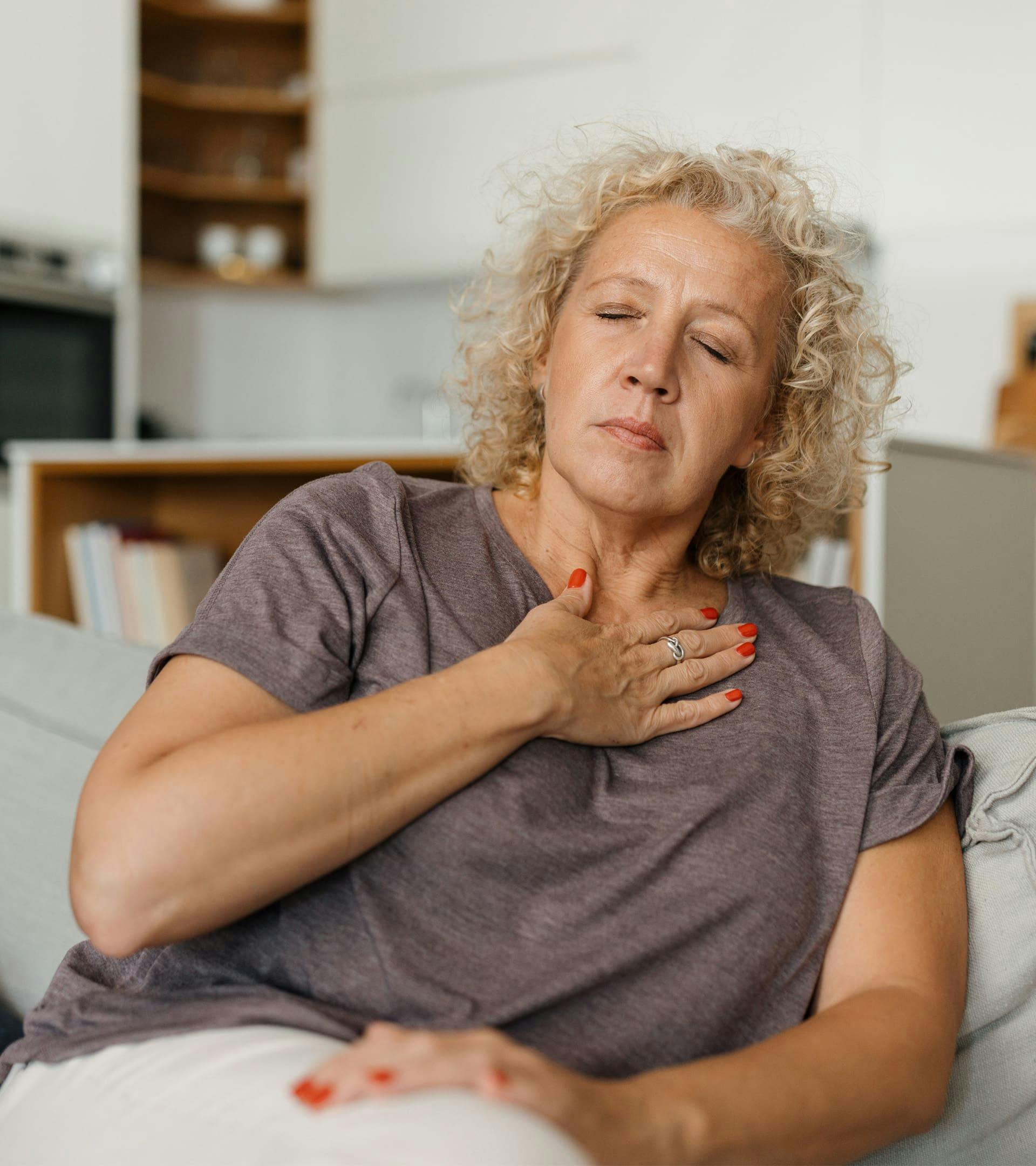 Woman holding upper chest in pain